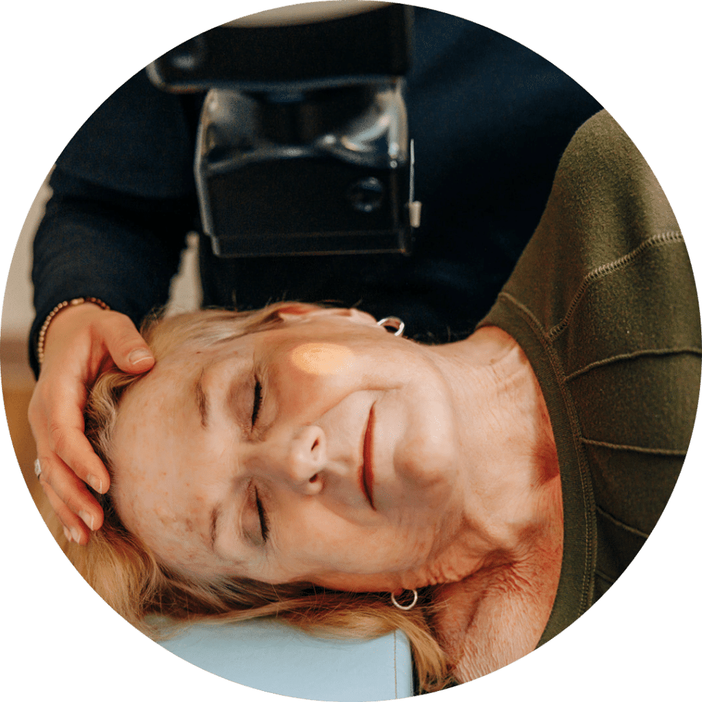 Closeup shot of a patient laying on her side while receiving EBT treatment. A light from the Mobetron machine focuses on a small patch of skin.